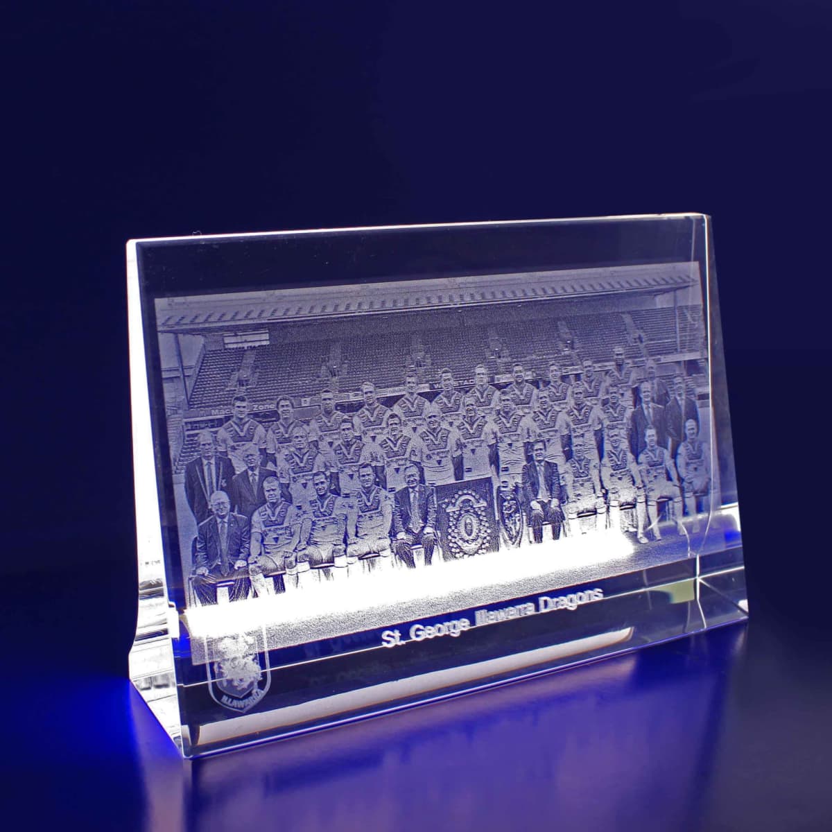 A rectangular clear crystal display featuring a detailed 3D image of a sports team, illuminated from below.