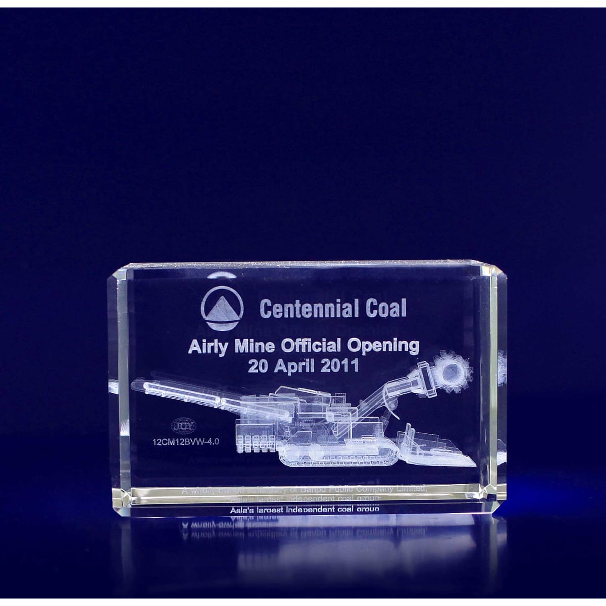 A rectangular clear crystal trophy featuring an engraved image of mining machinery and a logo.