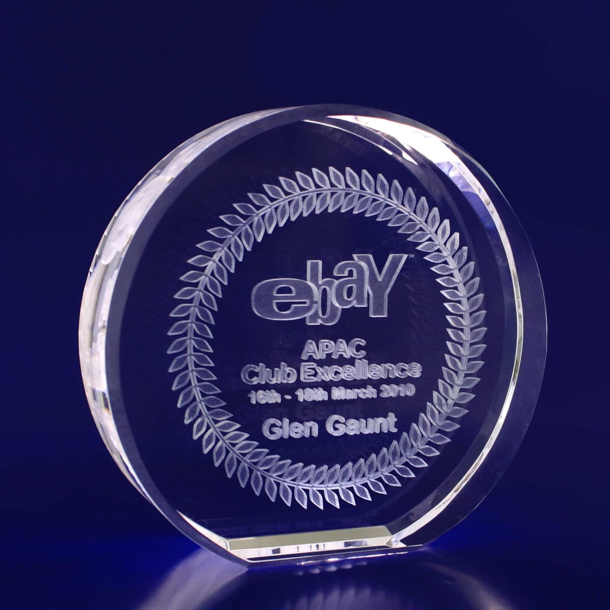 A 3D crystal round award with a 100mm diameter, featuring a clear design and engraved text.