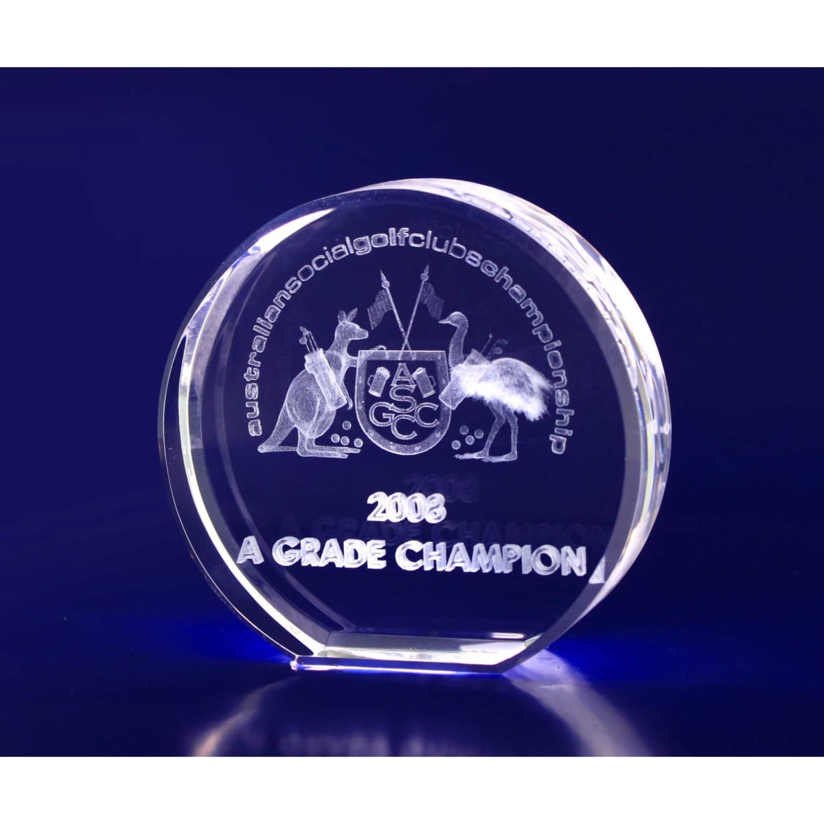 A round, clear crystal trophy with engraved details, featuring a logo and text highlighting "A Grade Champion" for 2002.