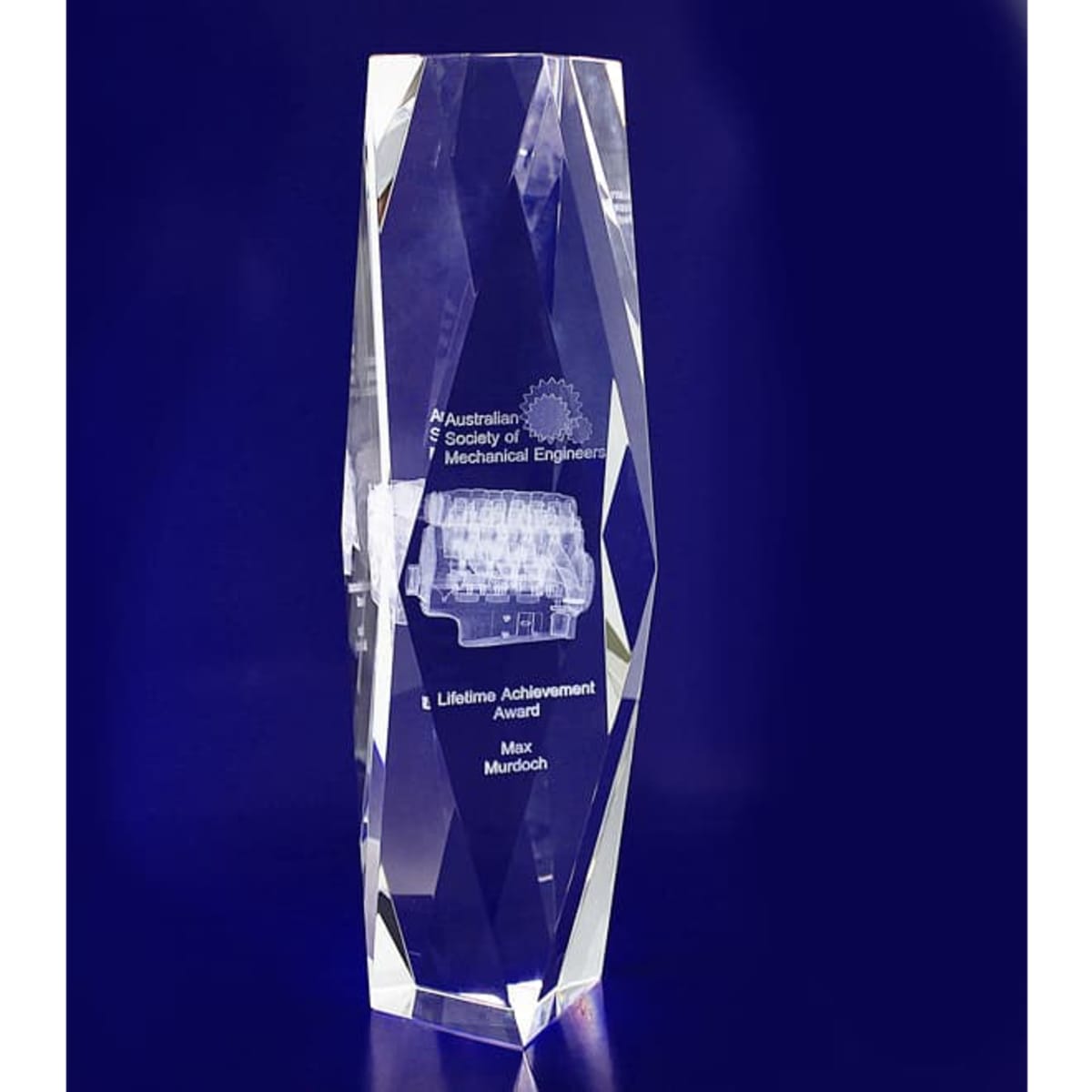 A crystal award with a bevelled tower shape, featuring a clear design and a branding logo.