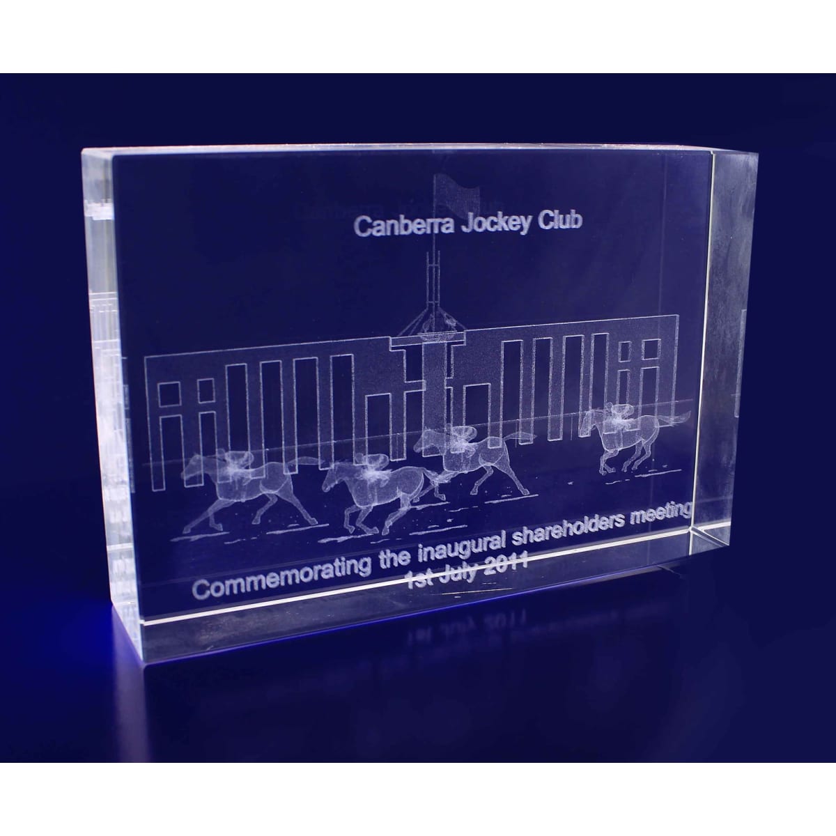 A rectangular, clear crystal plaque featuring etched designs and text, with a sleek and modern appearance.