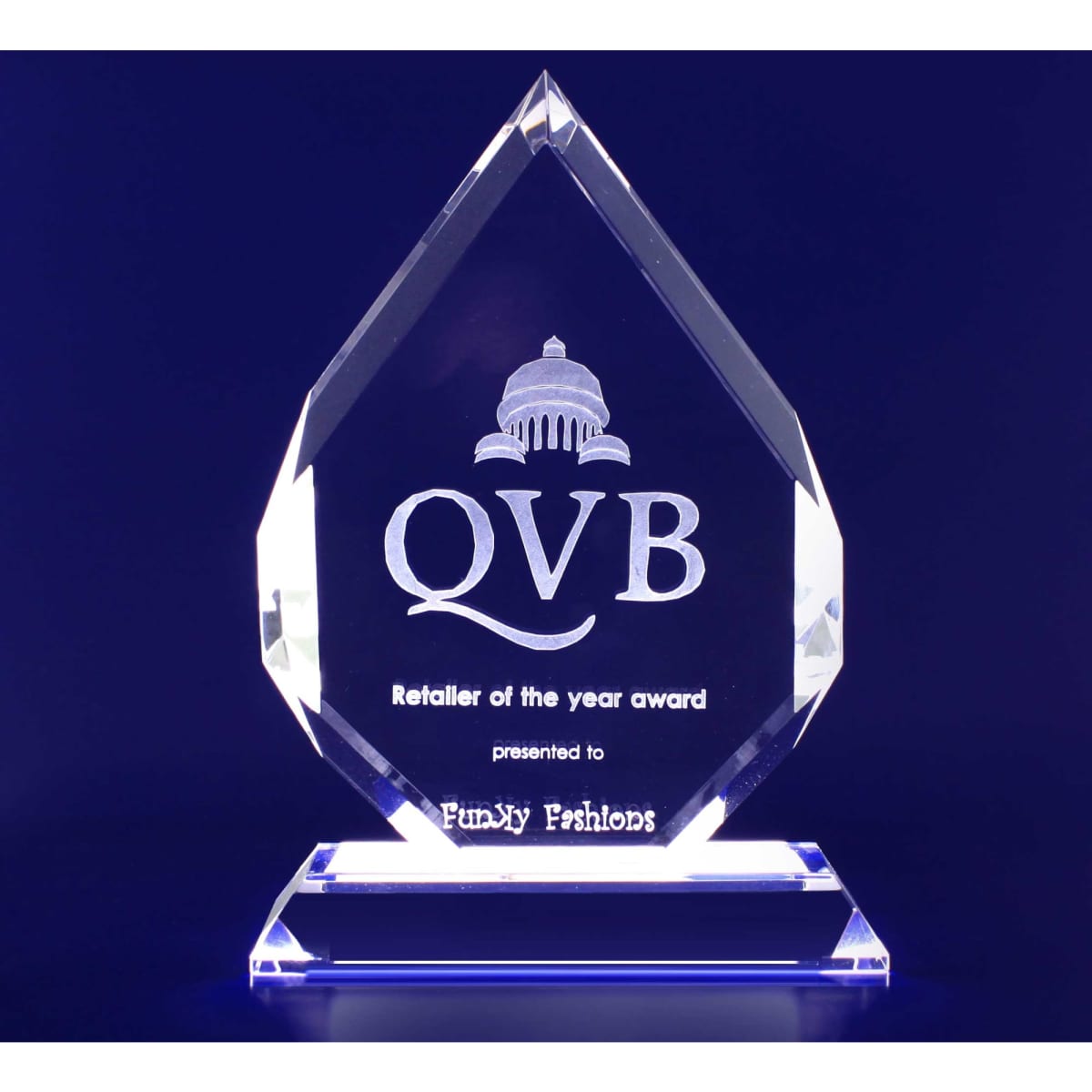 A clear crystal trophy in a tear-drop shape with a pedestal base. Features a logo and engraved text.