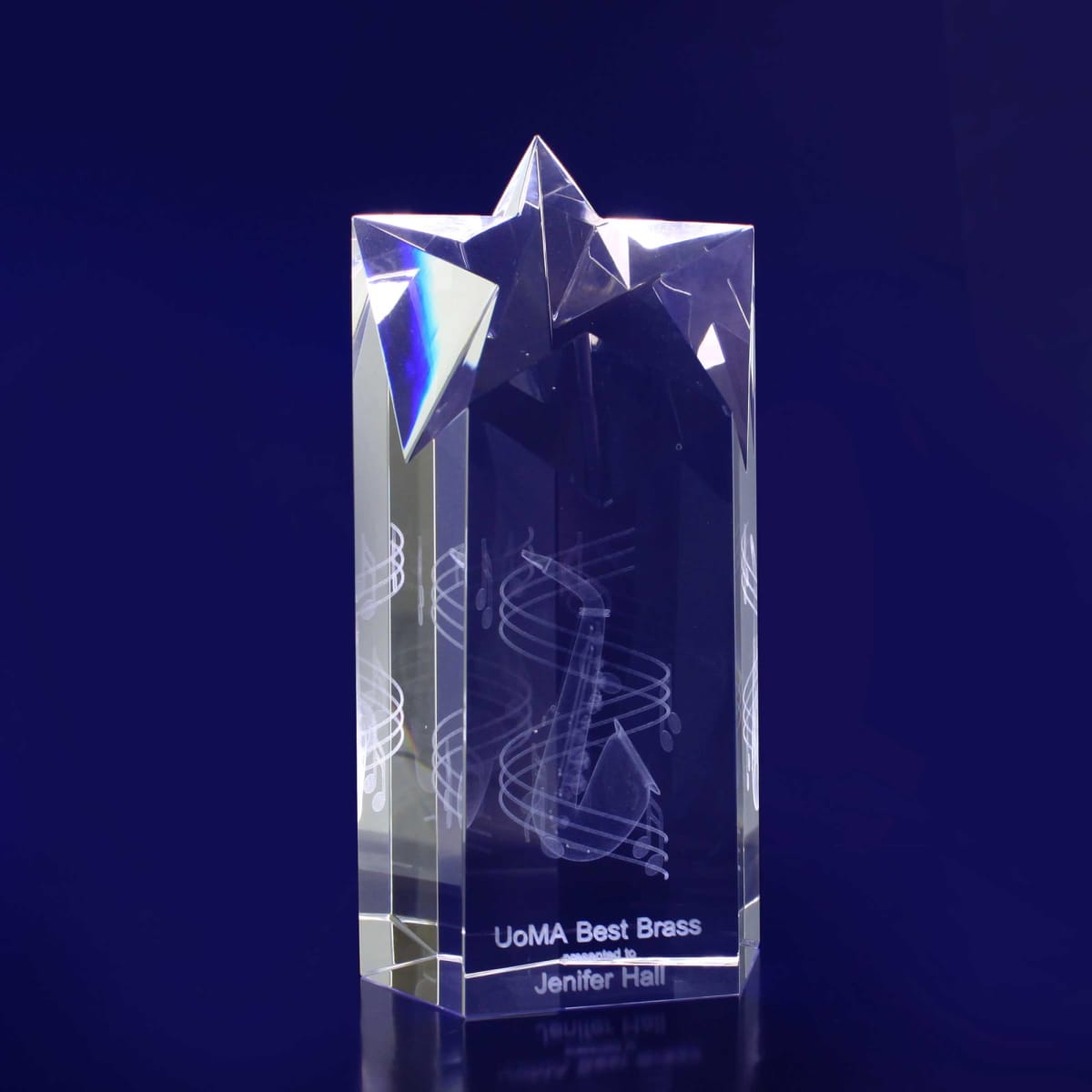 A crystal trophy in clear and reflective material, featuring a star point design at the top.