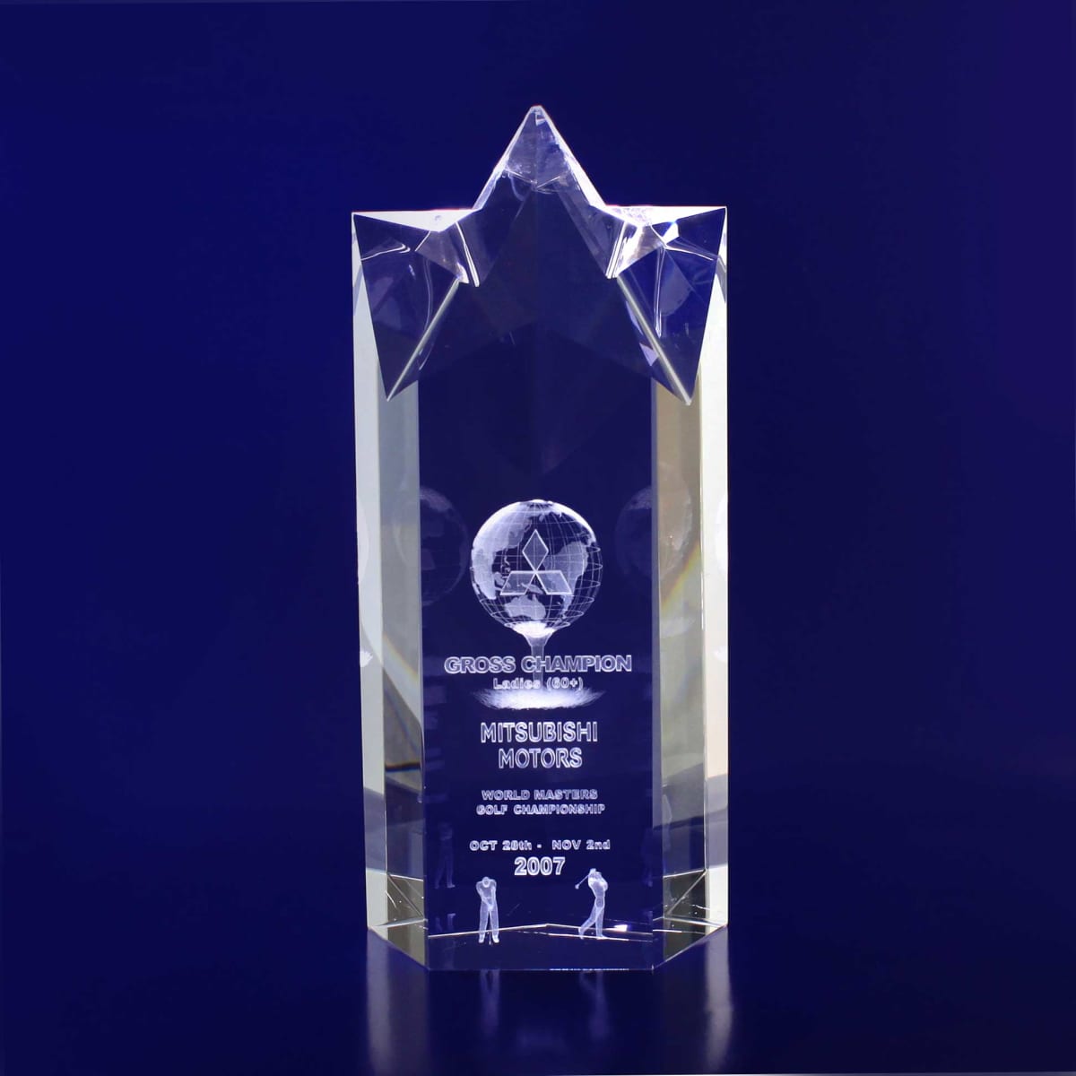 A clear 3D crystal trophy with a star point design, featuring a globe and etched text. The base is a rectangular shape.