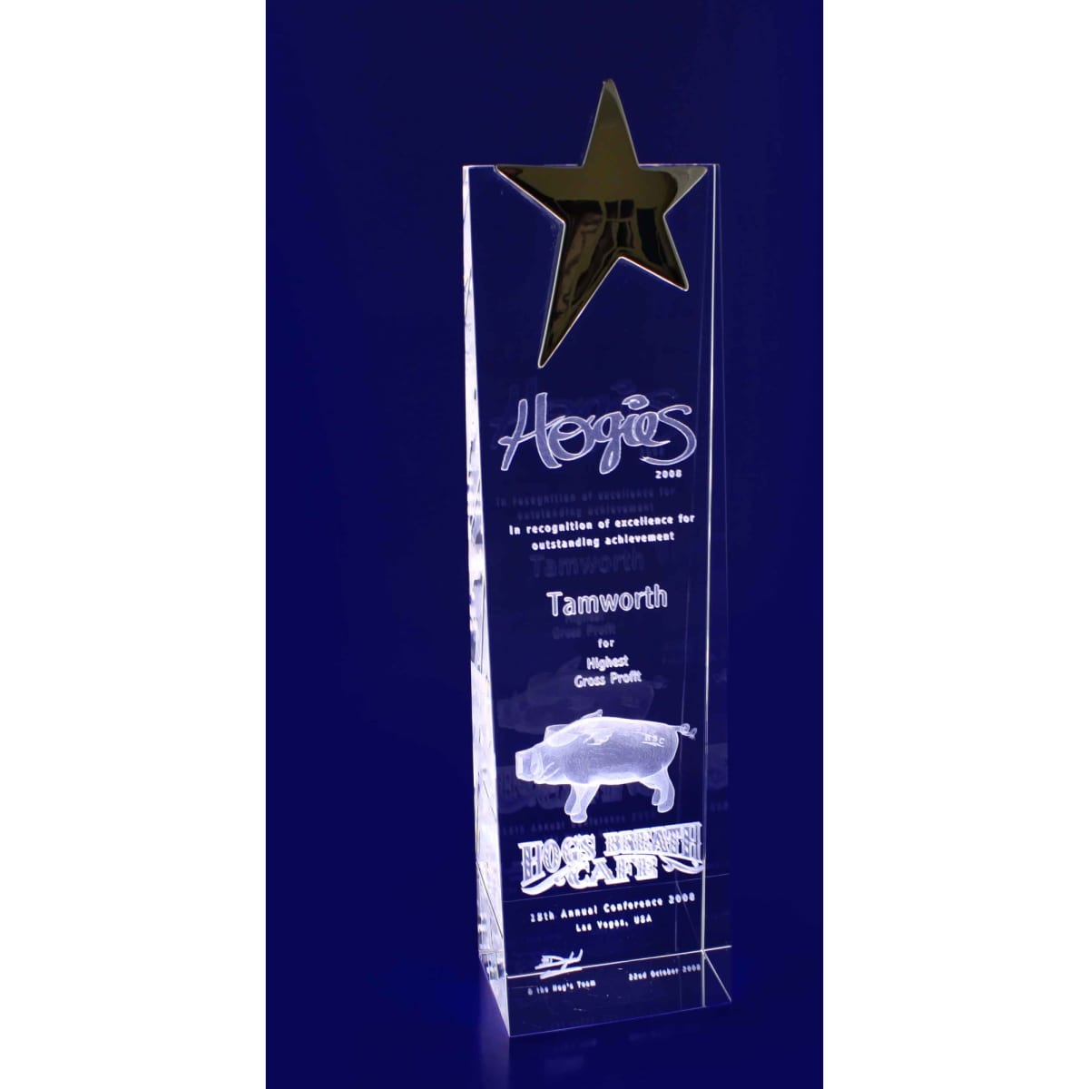 A clear crystal trophy in the shape of a star wedge, featuring an engraved design and a small logo.