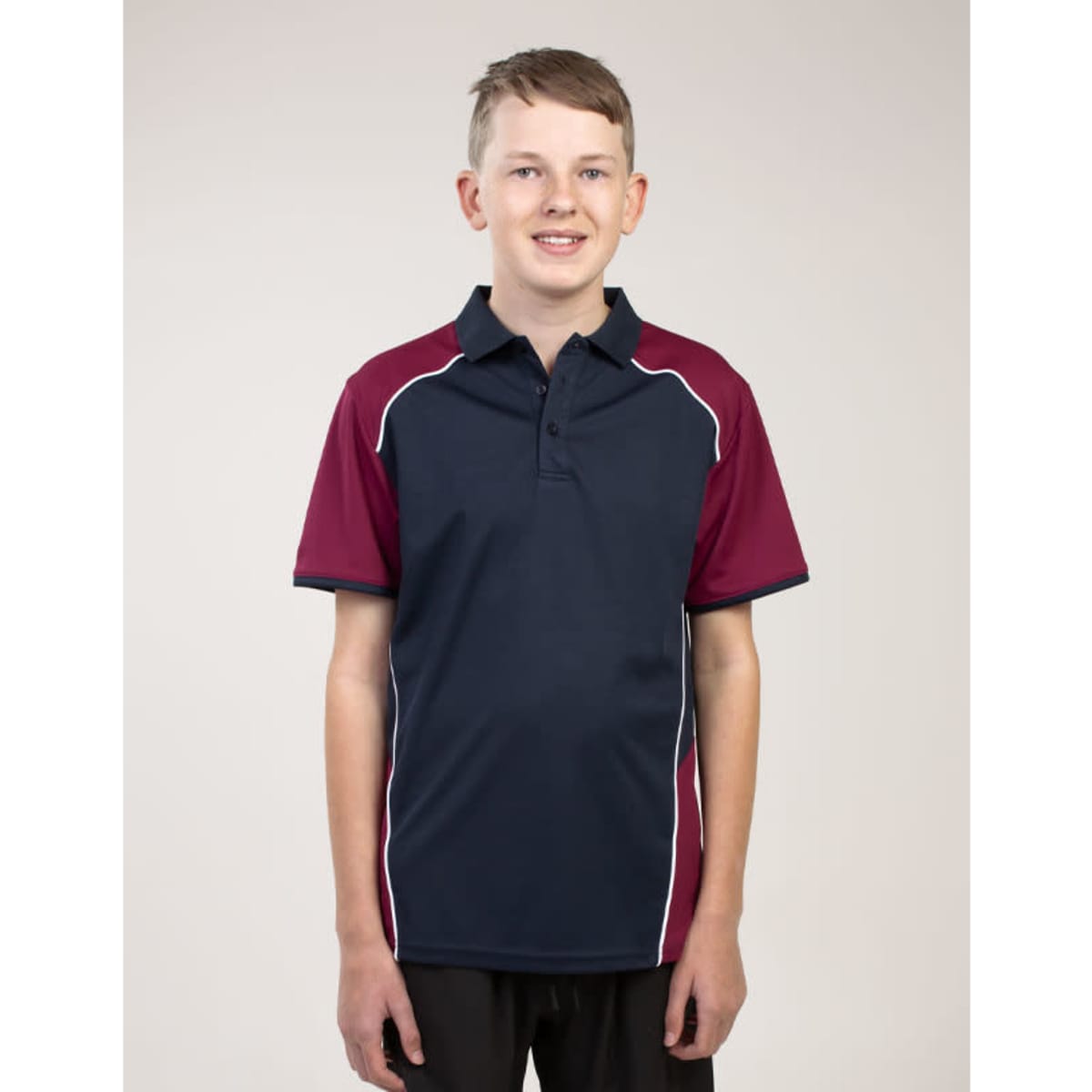 A young person wearing a navy and maroon polo shirt with a logo. The shirt features white piping along the seams.