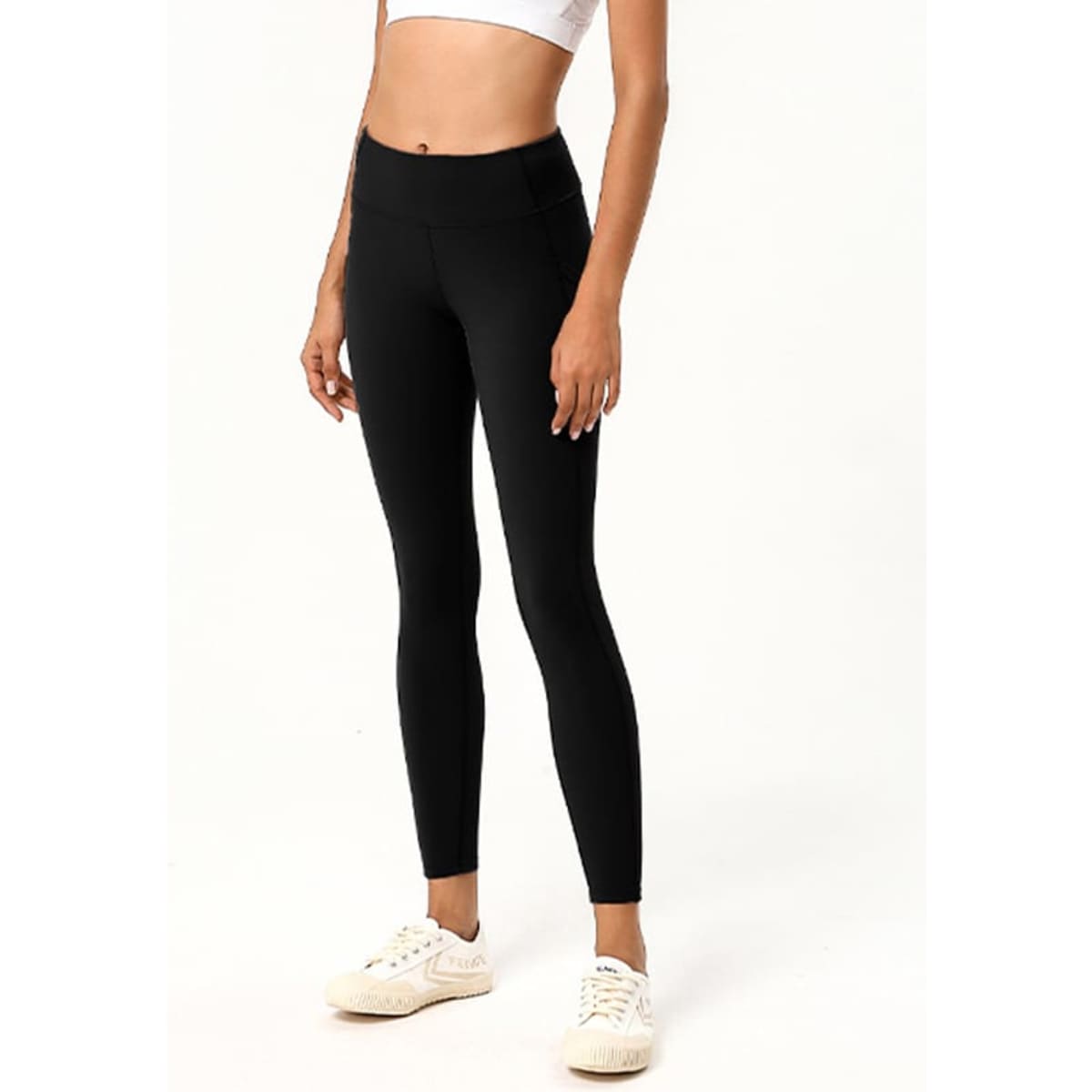 Black ladies' leggings featuring a high waistband and fitted design, paired with white sneakers.