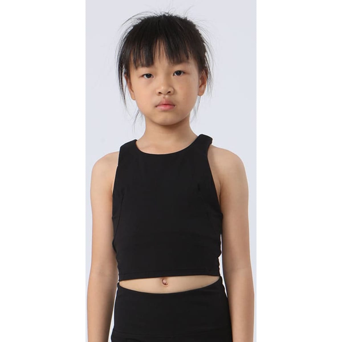 A girl's black crop top with a simple design, featuring a sleeveless style and a fitted silhouette.