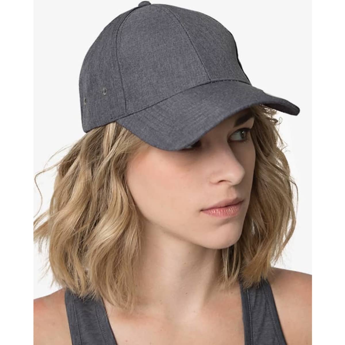 A grey cap with a curved brim, featuring a logo, worn by a woman with wavy hair.