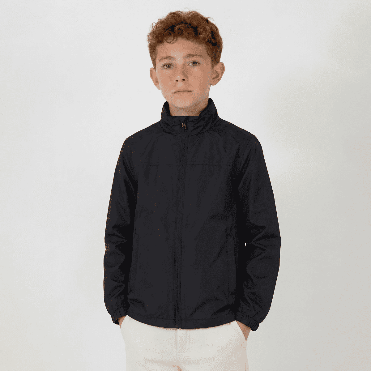 A youth jacket in navy blue with a zip front, featuring long sleeves and a high collar. It has a logo on one side.