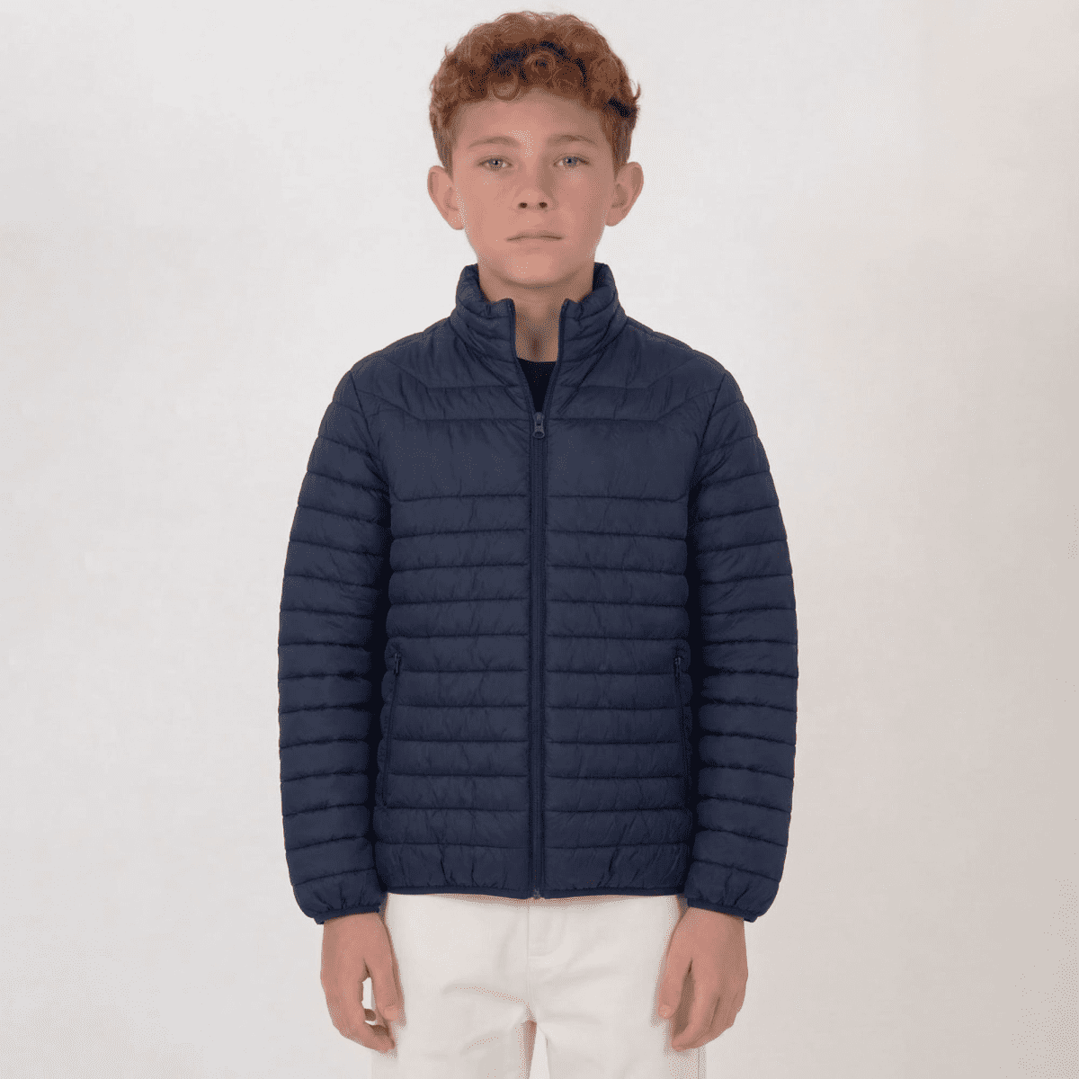 A navy puffer jacket designed for youth, featuring a full zip and a stand-up collar. It has a logo on it.