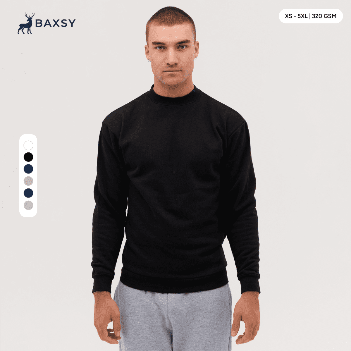 A crew sweatshirt in black, featuring long sleeves and a round neckline. The model is standing against a neutral background.