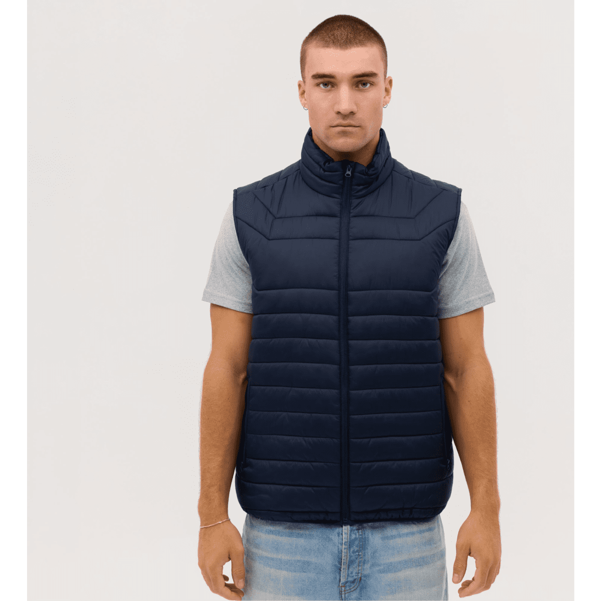 A navy blue puffer vest with a zip front, featuring a high collar and a simple design, on a model.