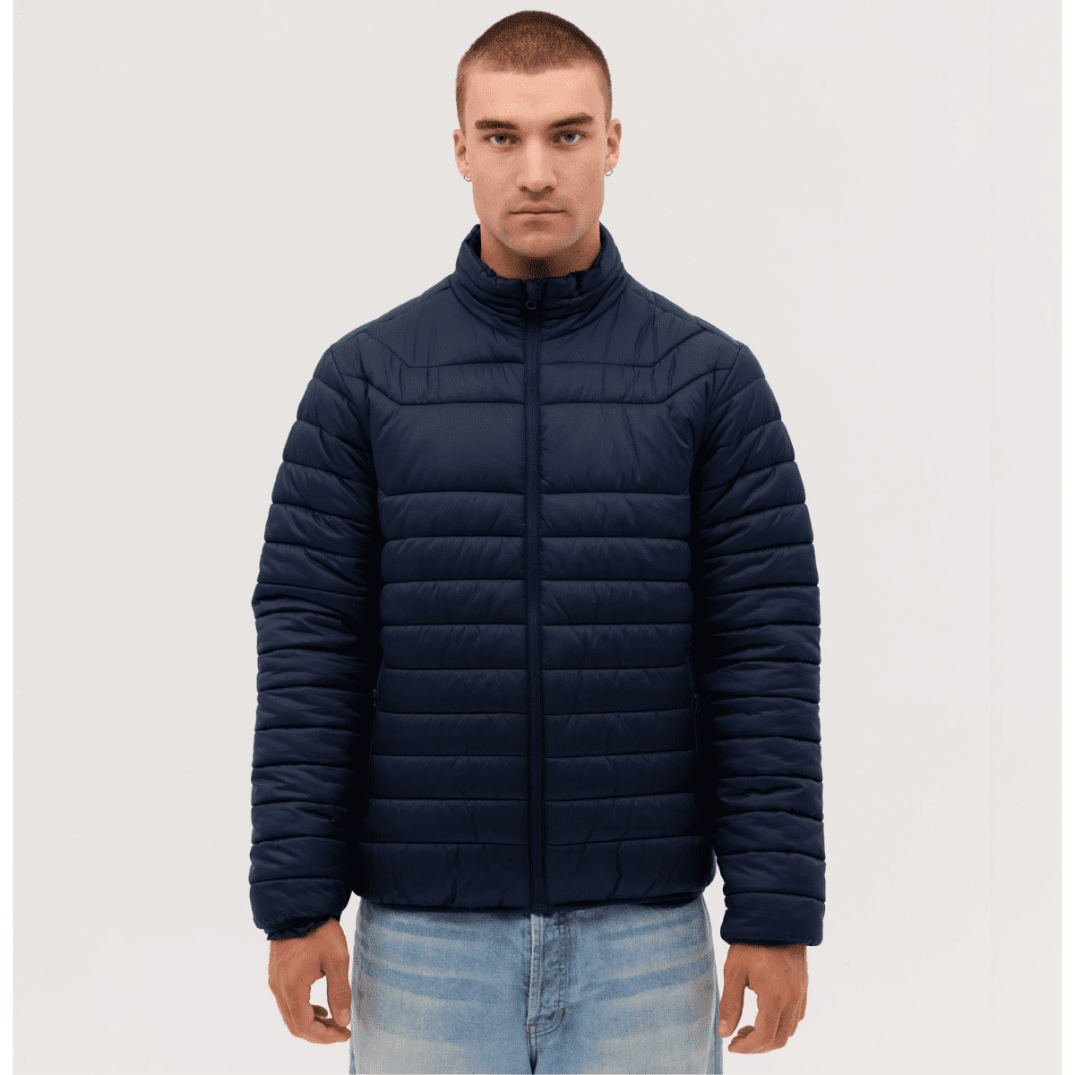 A navy puffer jacket with a high collar and zippered front, displayed on a male model against a plain background.