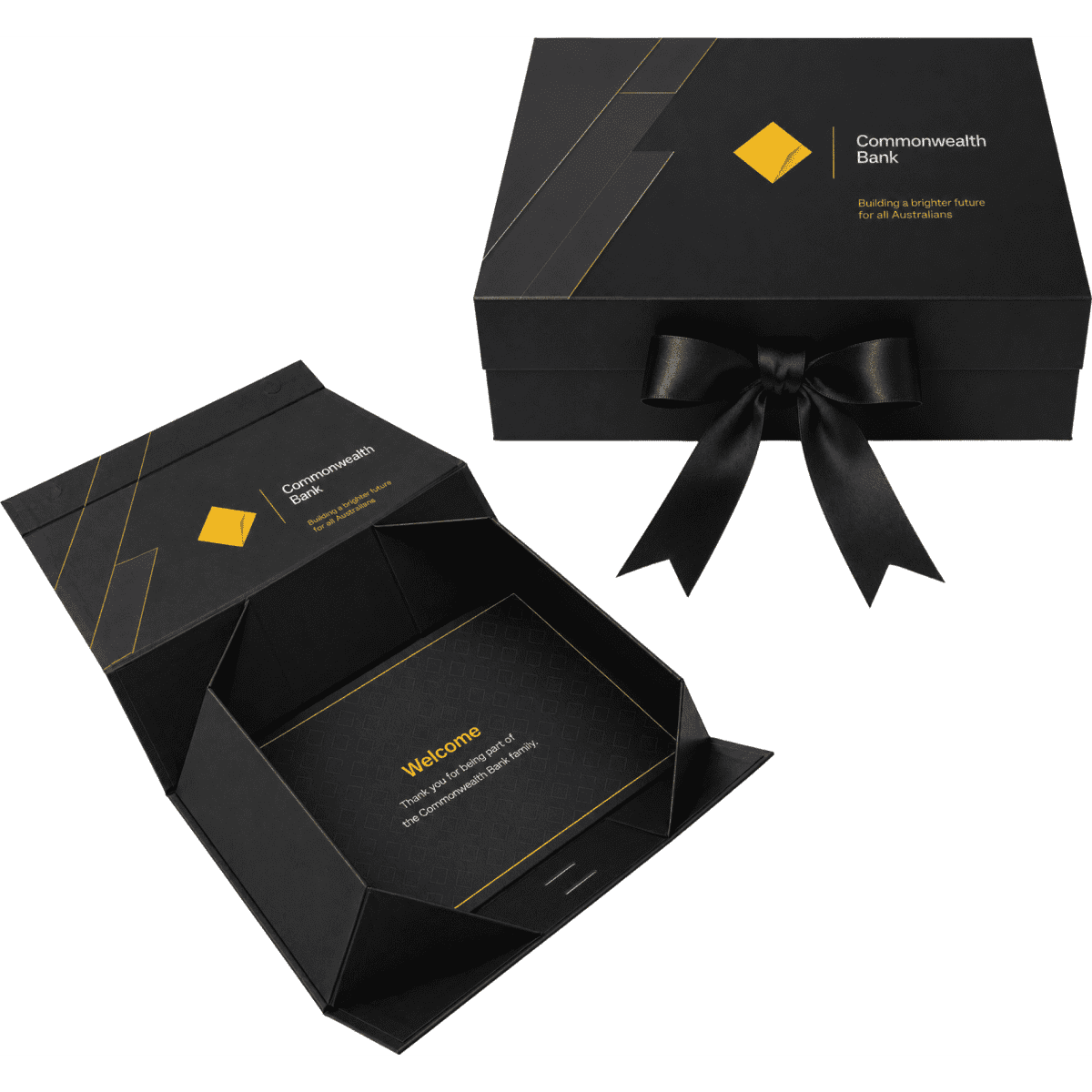 A large black gift box with a gold geometric design and black ribbon, featuring an interior greeting card.
