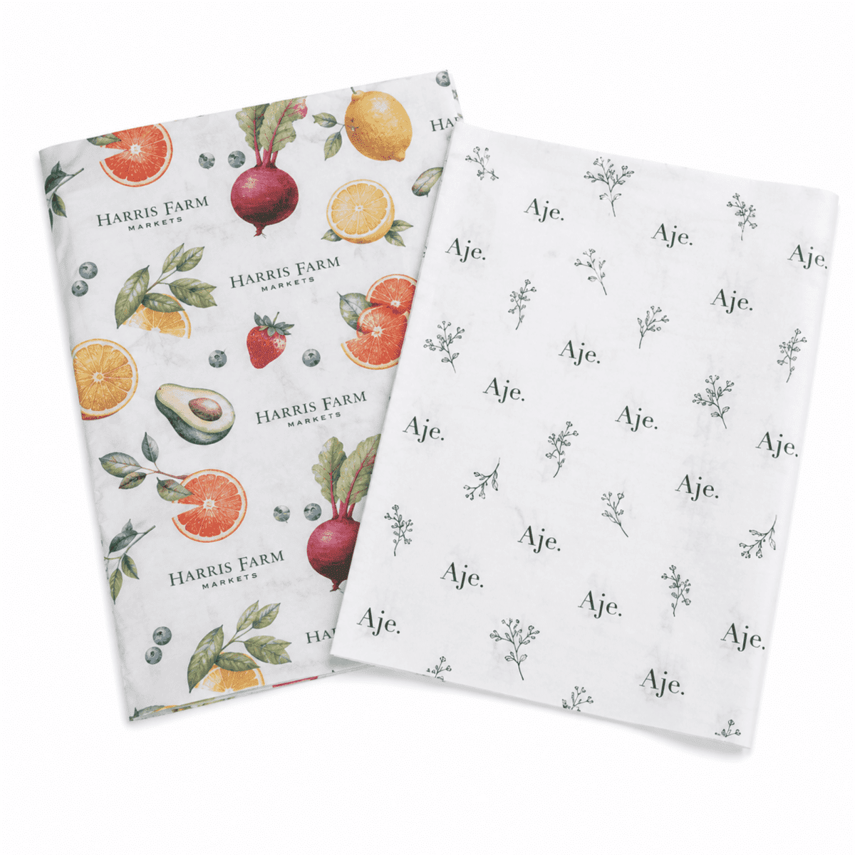 Two sheets of patterned Kraft paper, featuring fruits and floral designs in vibrant colours. One sheet has a logo.
