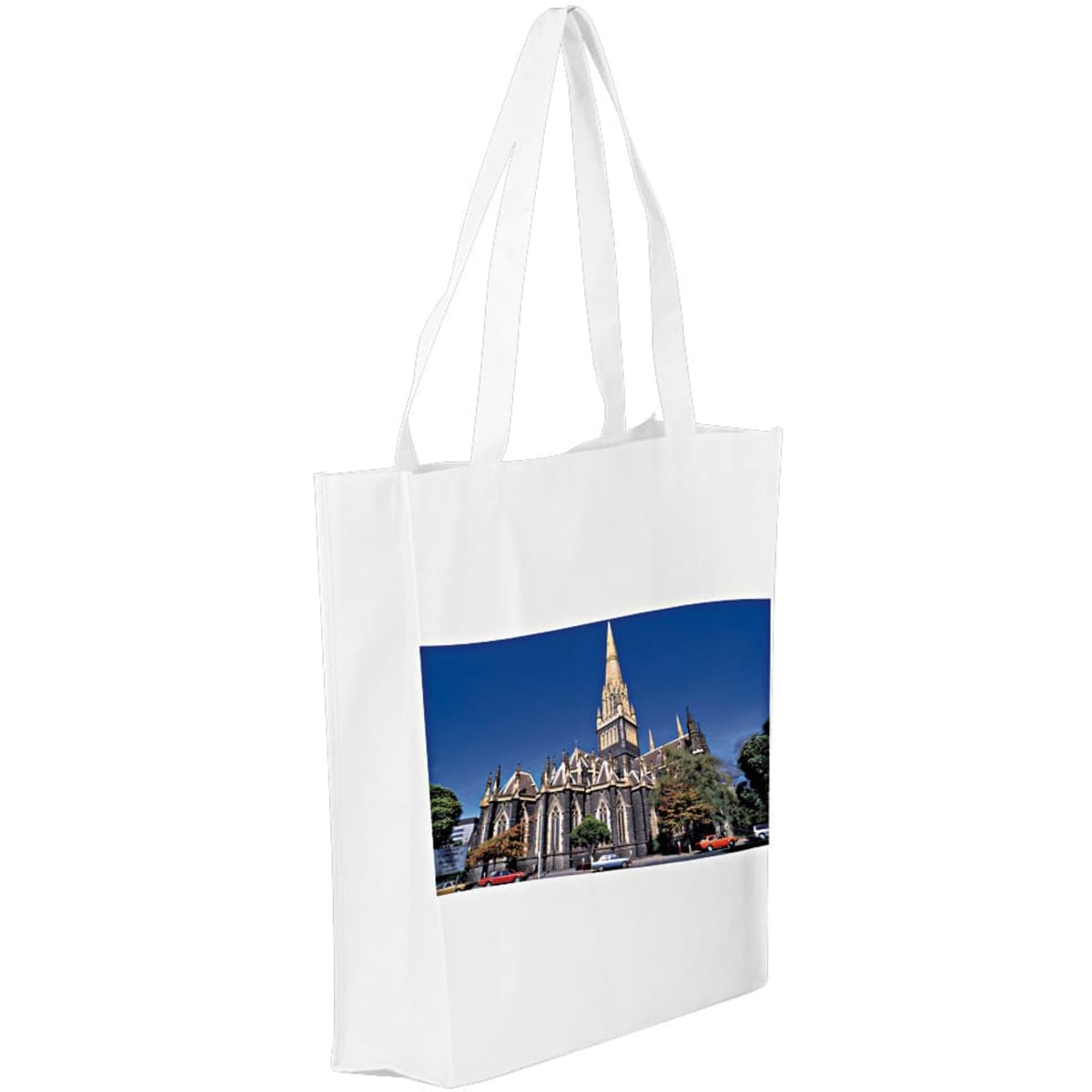 A white tote bag featuring a panoramic image of a church with a tall spire against a blue sky.
