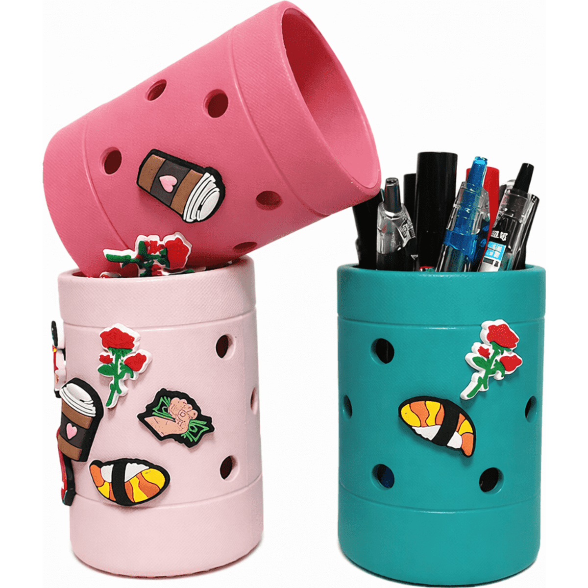 Two pencil holders in pink and teal, decorated with various stickers and featuring holes for ventilation.
