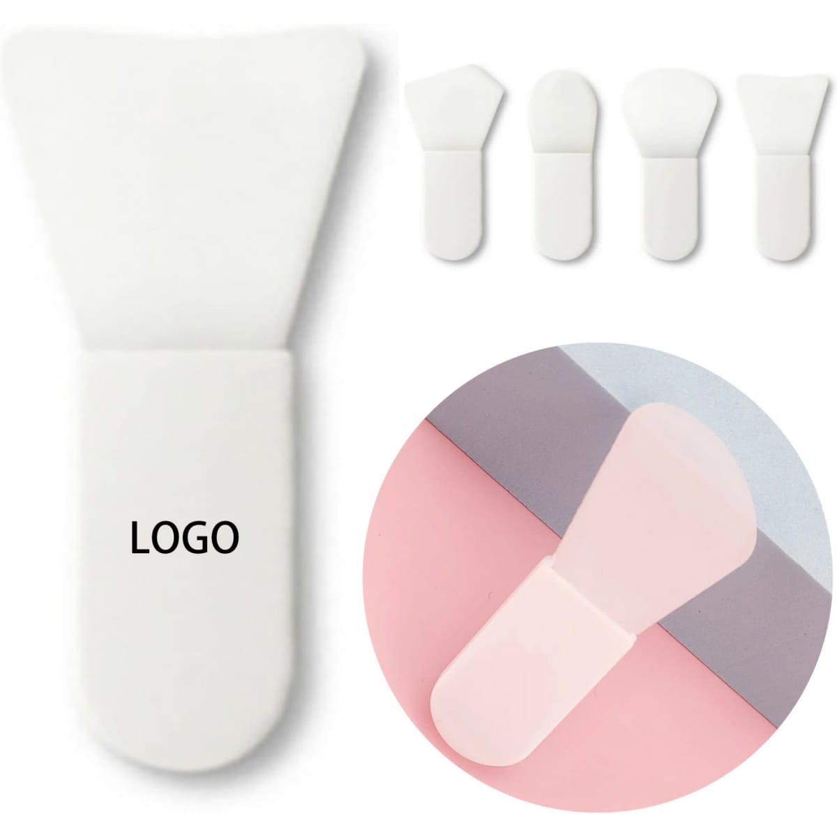 A silicone face mask brush in white, featuring a rounded tip and three additional similar brushes in a circular inset.