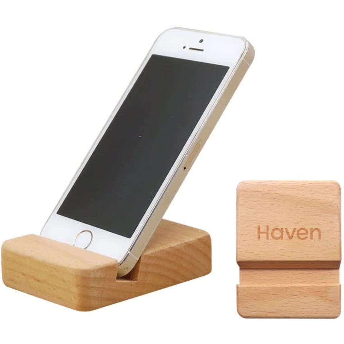 A wooden phone stand with a light finish holding a smartphone, accompanied by a small wooden block with a logo.