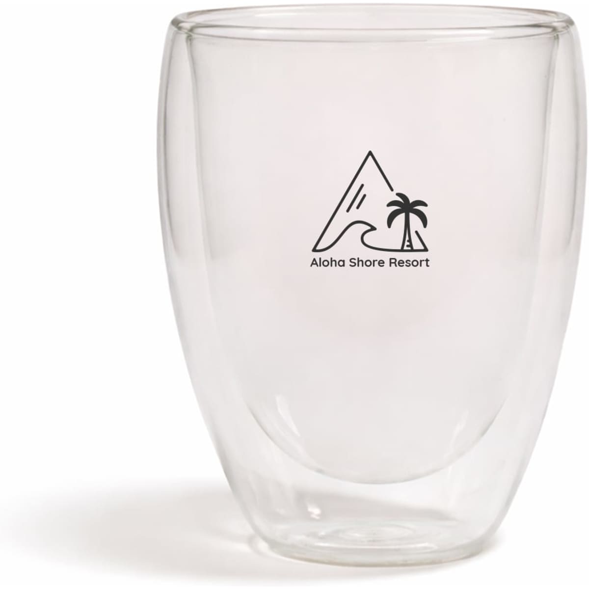 A double-walled glass cup with a transparent design and a logo featuring a mountain and palm tree.