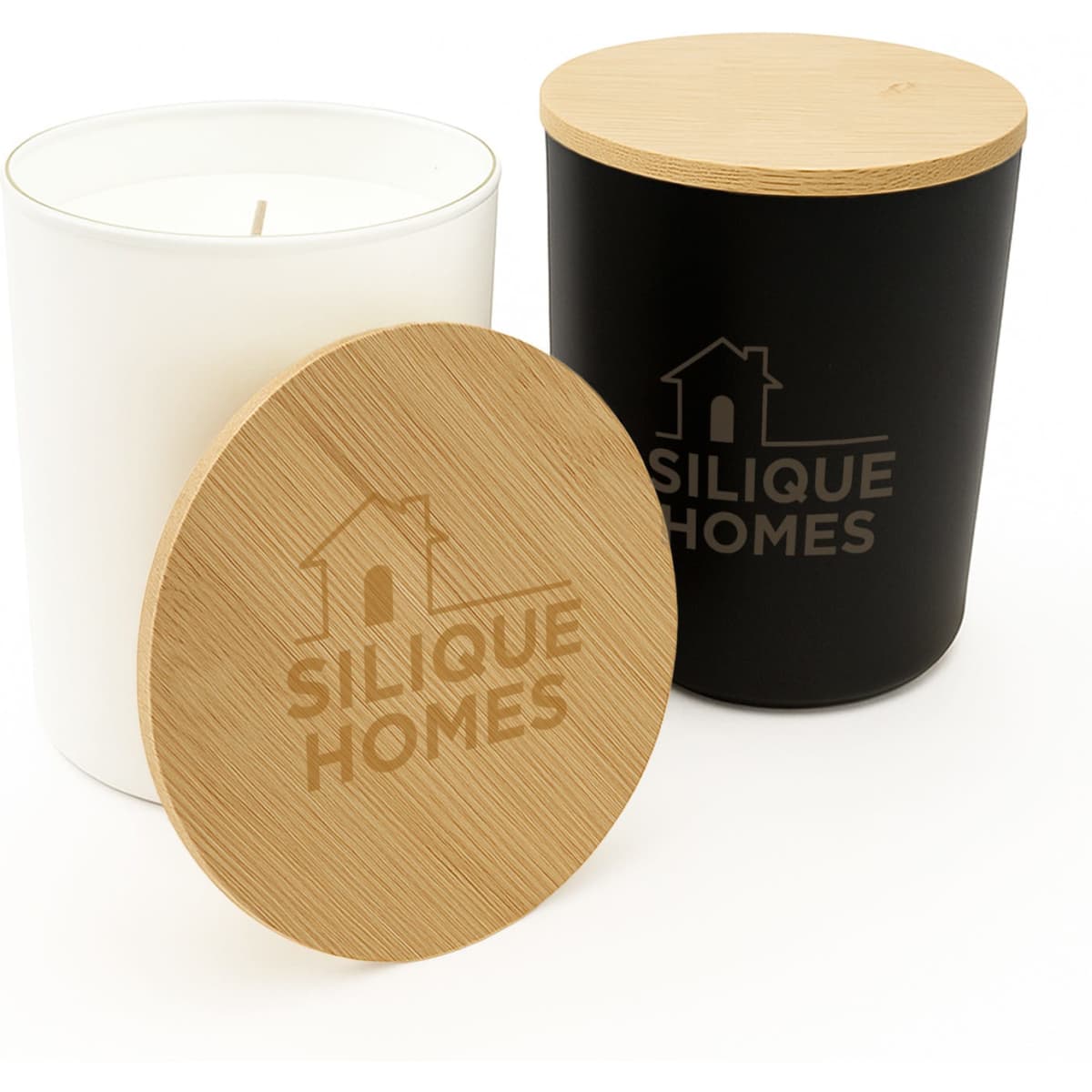 A medium-sized glass candle with a white container, wooden lid, and a black container beside it, both featuring a logo.