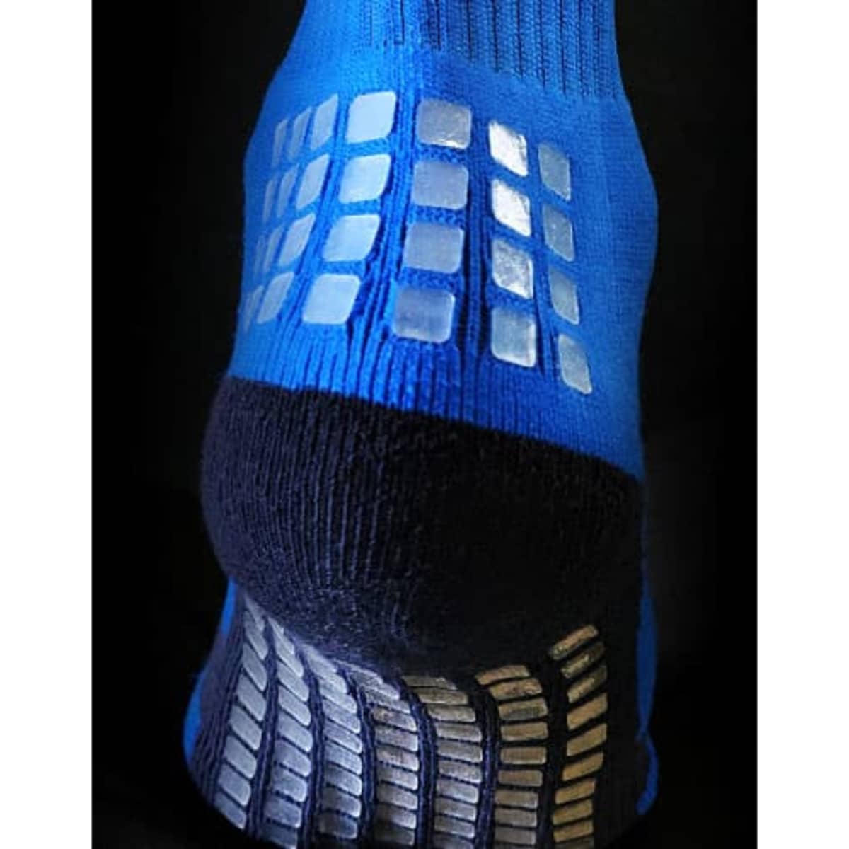 A pair of thick athletic socks in blue and black with gripped patterns on the sole and heel.