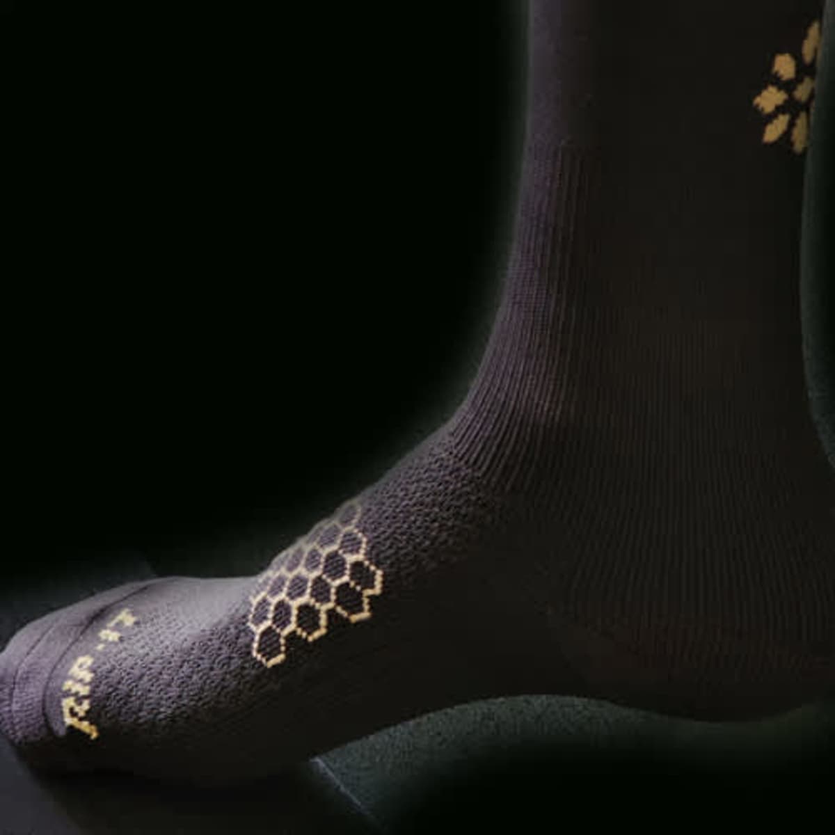 Black soccer socks with silver antibacterial detailing featuring a honeycomb pattern and a logo.