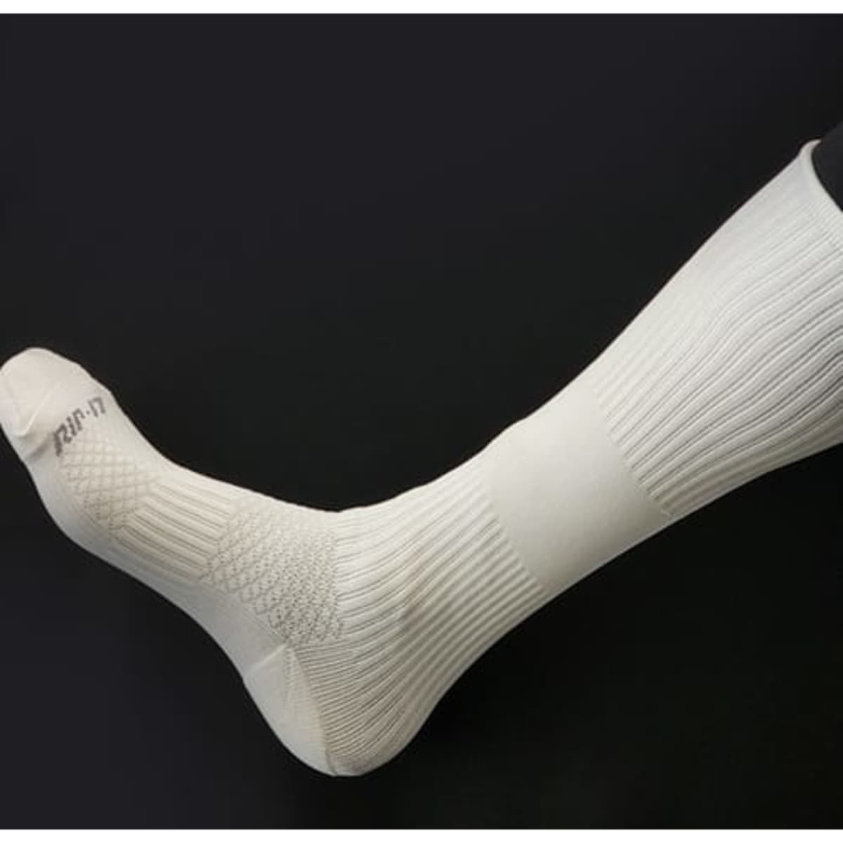 White softball socks featuring a textured design and a logo, designed with silver anti-bacterial properties.