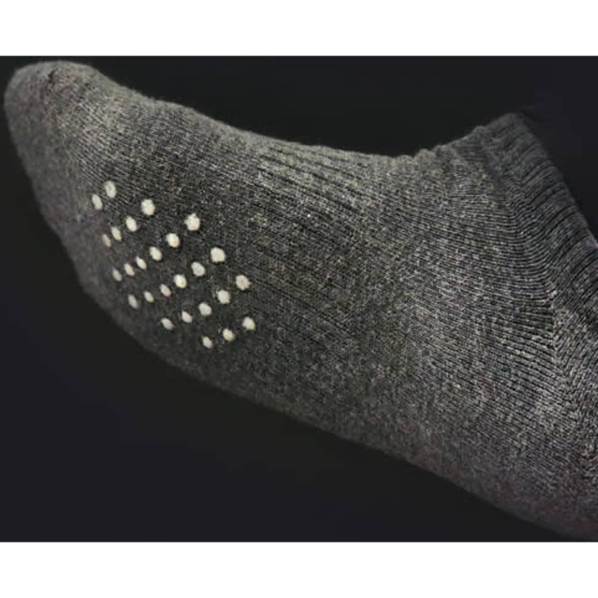 A pair of low-cut grey socks with white anti-slip dots on the bottom. The texture appears padded and cotton.