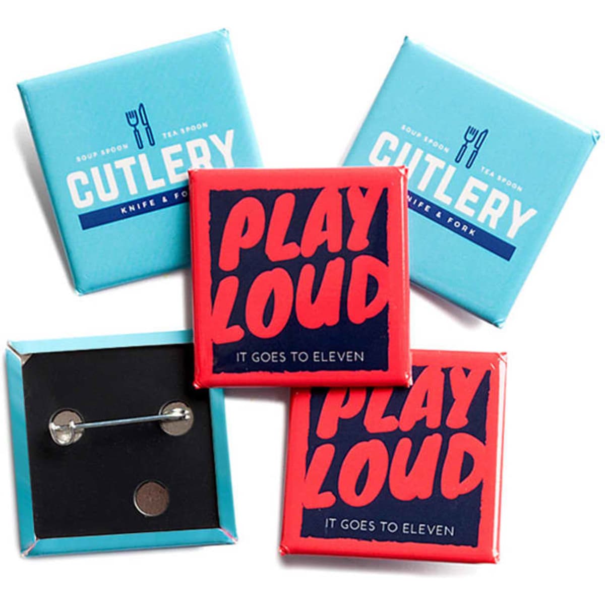 A set of three square badges in red and blue packaging, featuring a silver pin fastening.