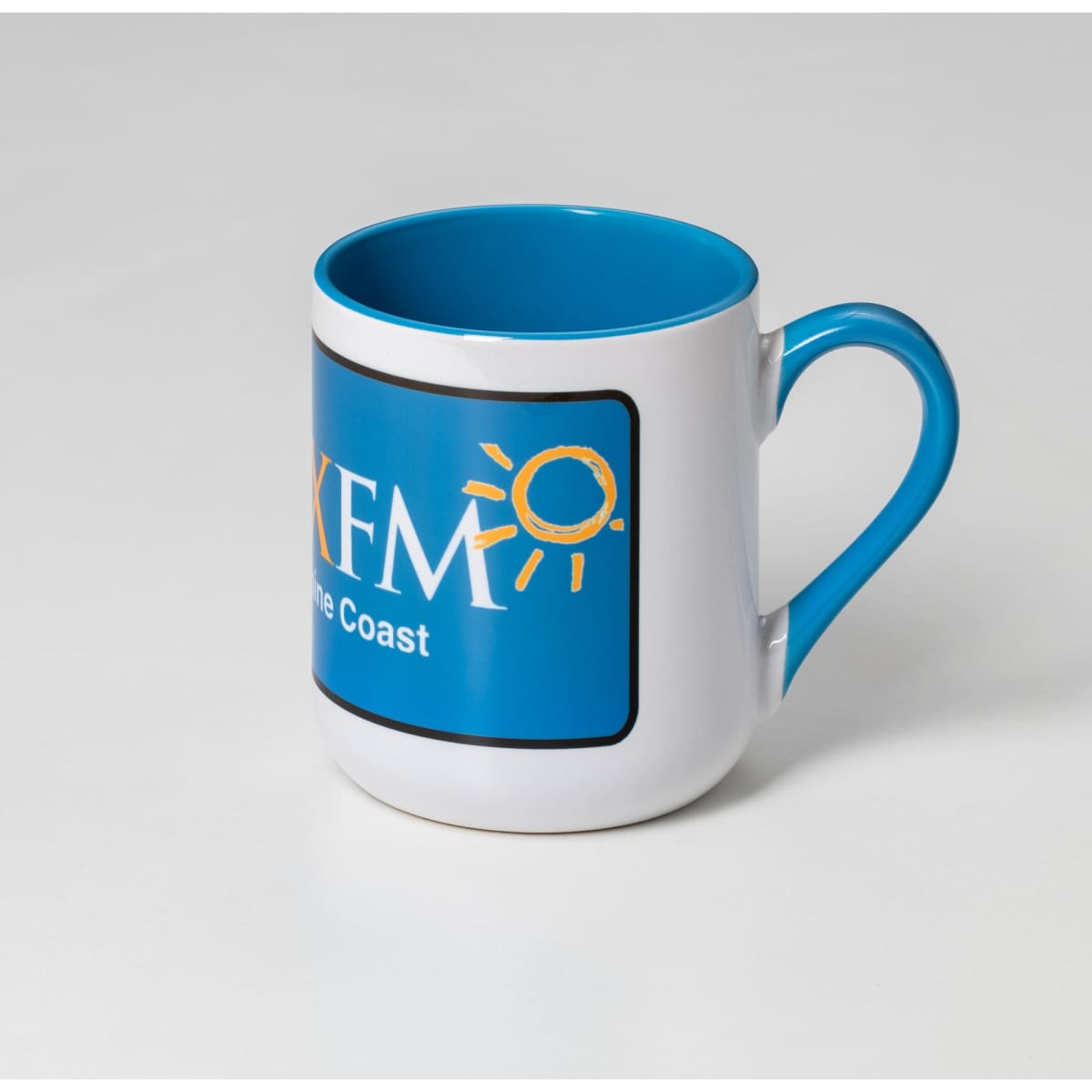 A coffee mug featuring a white exterior and a blue interior, with a logo on one side.
