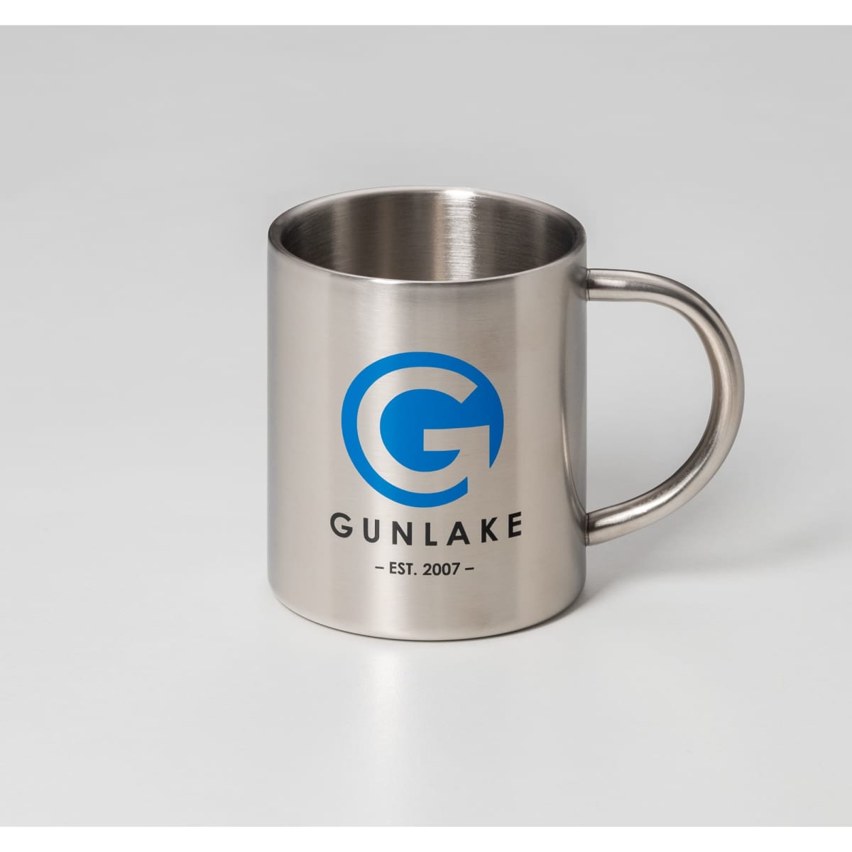 A stainless steel travel mug featuring a handle and a logo. The mug has a shiny metallic finish.