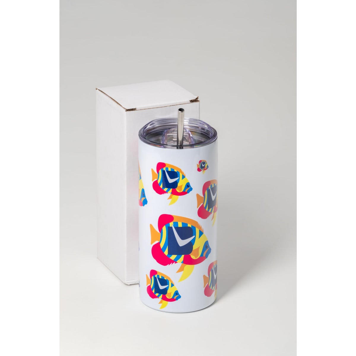 A drink tumbler with a colourful fish design, featuring a clear lid and straw, packaged in a white box.