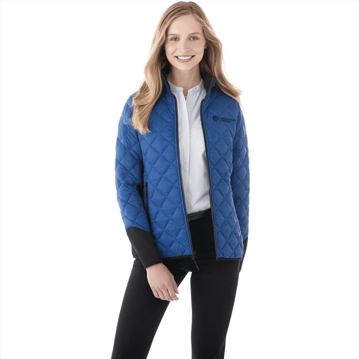 A woman wearing a blue quilted insulated jacket with a black collar and cuffs, featuring a logo.