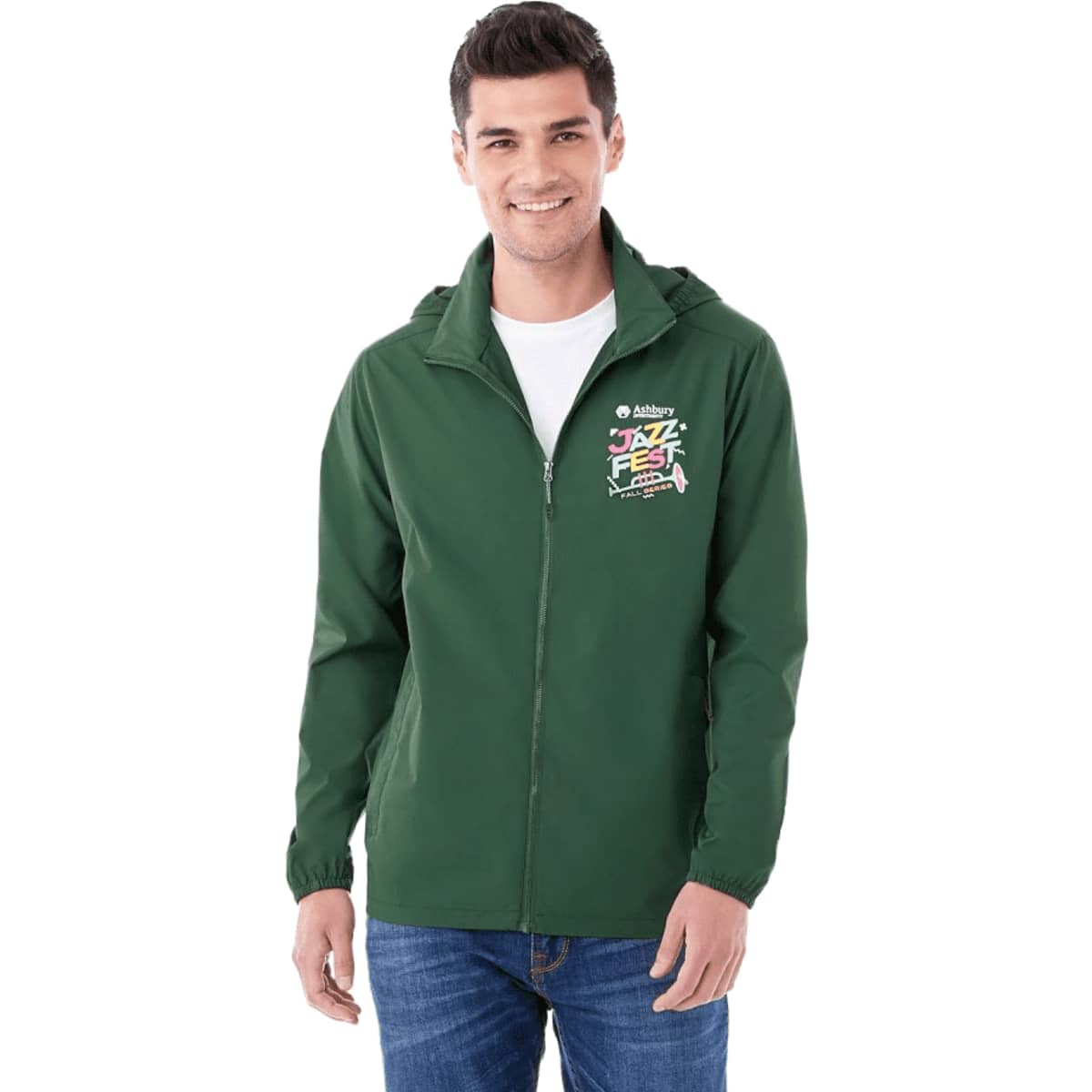 A man wearing a green packable rain jacket with a hood and a logo on the chest.