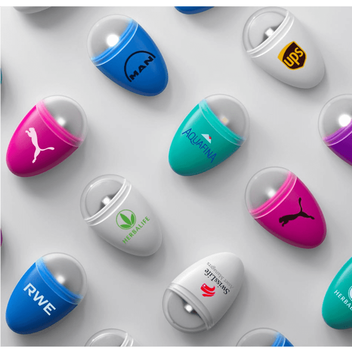 A collection of colourful capsule-shaped water bottles featuring various logos, in shades of blue, pink, purple, and white.