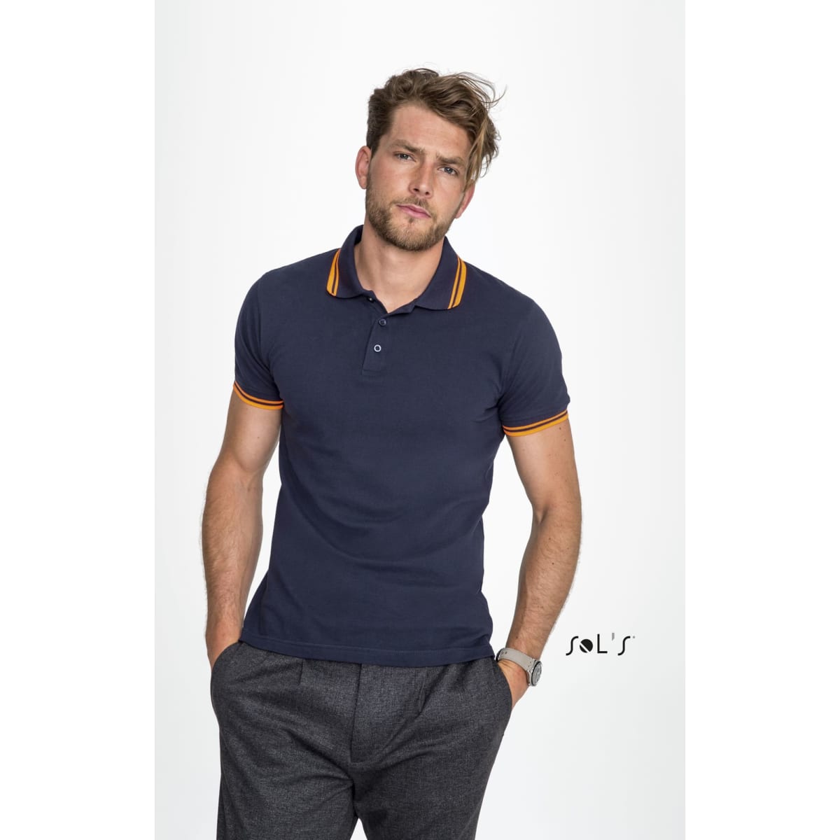 A men's polo shirt in navy blue with orange striped collar detailing. It features branding.