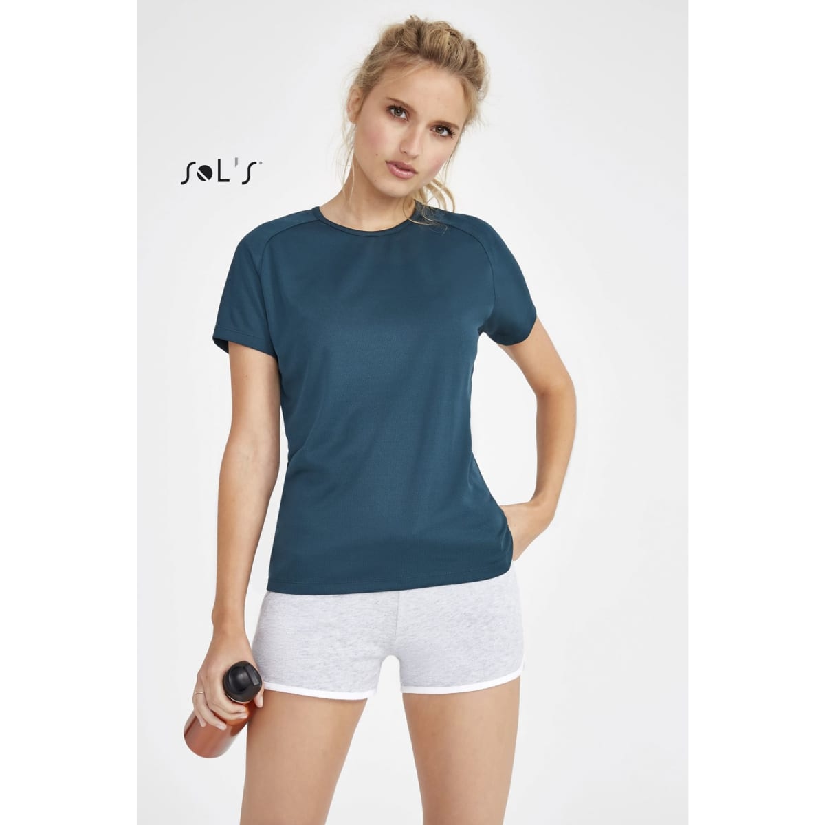 A women's sporty T-shirt in navy blue, featuring raglan sleeves and made from 100% breathable polyester, with a logo.