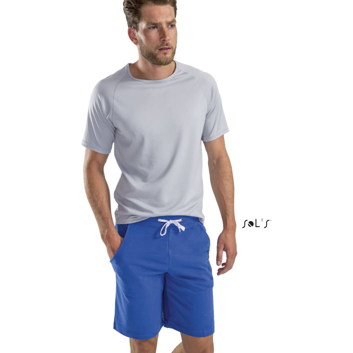 A man models casual style shorts in blue, paired with a light grey t-shirt. The image includes a logo.