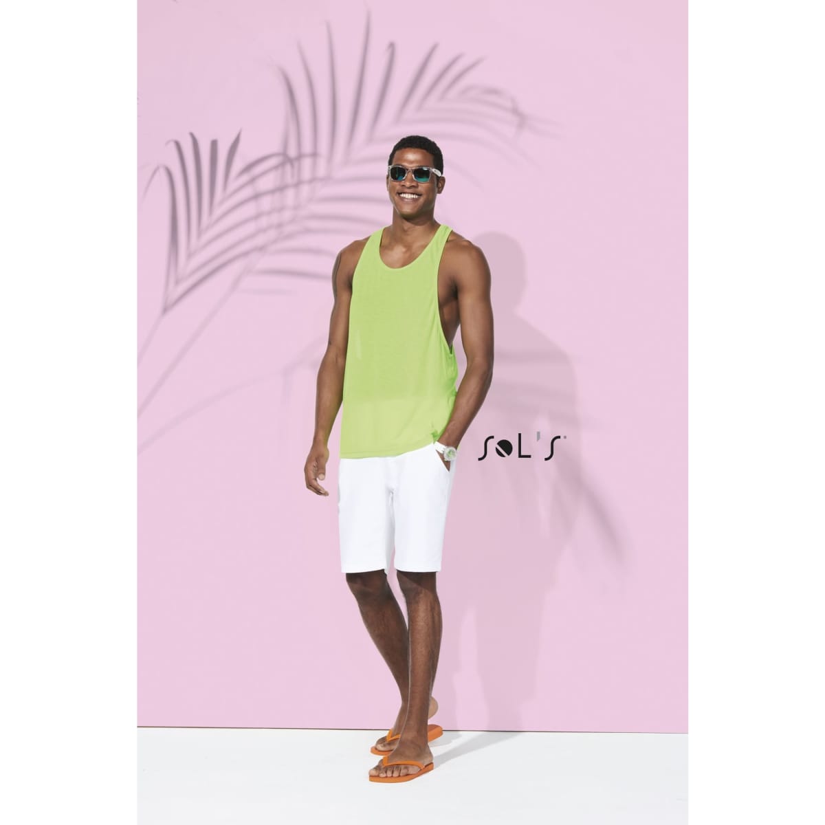 A unisex singlet tank top in bright green, worn by a model in white shorts and sunglasses, with a logo present.