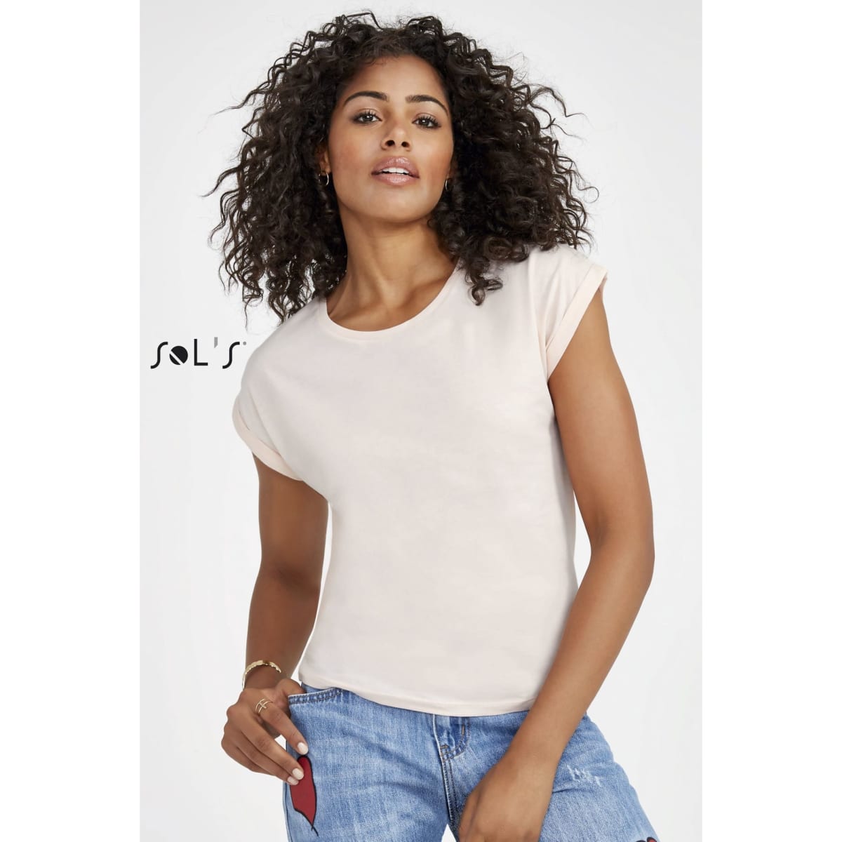 A women's round neck T-shirt in a soft peach colour with seamless armholes, made from 100% semi-combed ring spun cotton.