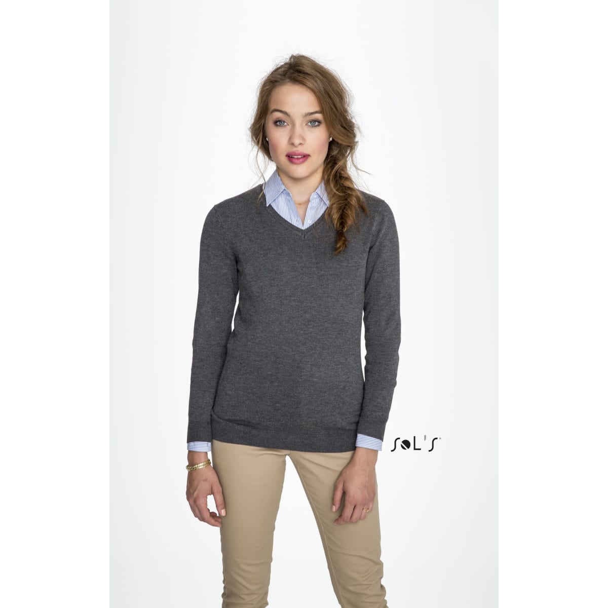 A women's V-neck jumper in charcoal grey, paired with a light blue collared shirt, modelled by a woman.