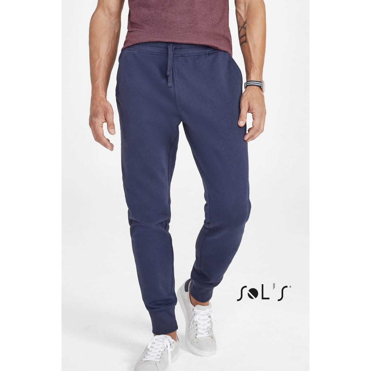 Navy slim fit track suit pants for men, featuring side pockets and a drawstring waist, with a logo on the side.