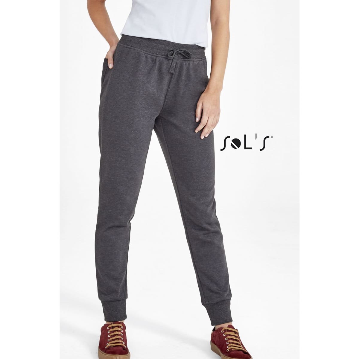 Slim fit women's track suit pants in grey, featuring an elastic waistband and cuffs, with a logo present.