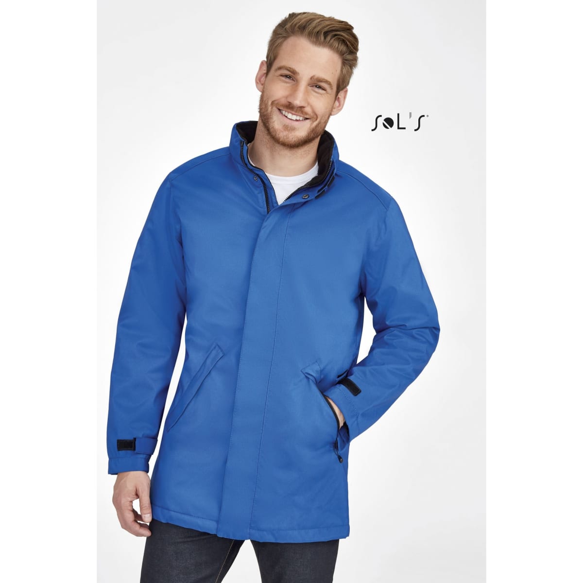 A man wearing a blue unisex jacket with a fleece-lined collar and a logo.