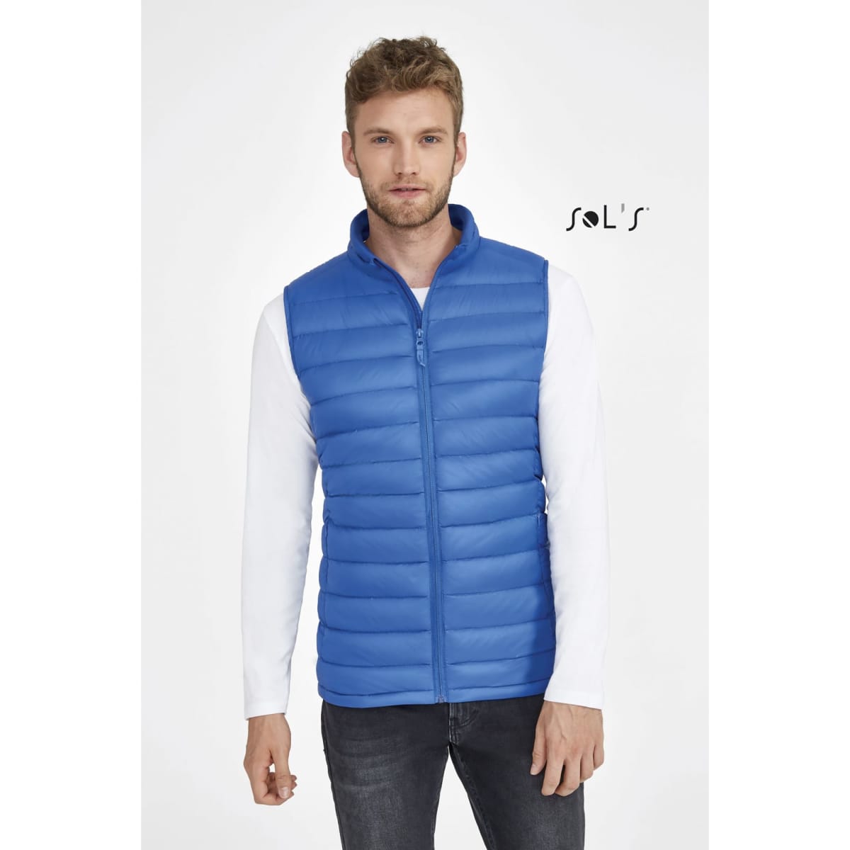 A blue puffer vest featuring a zip front and horizontal stitching, worn by a model. The vest includes a logo.