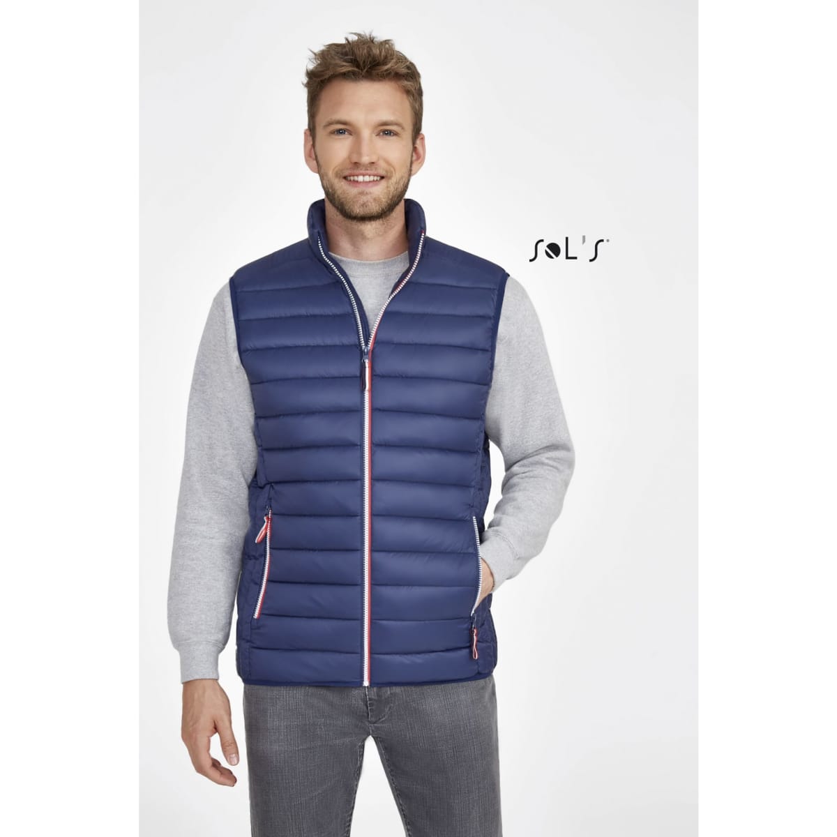 A navy lightweight puffer vest with pink detailing, featuring a zip front and side pockets. It has a branding logo.