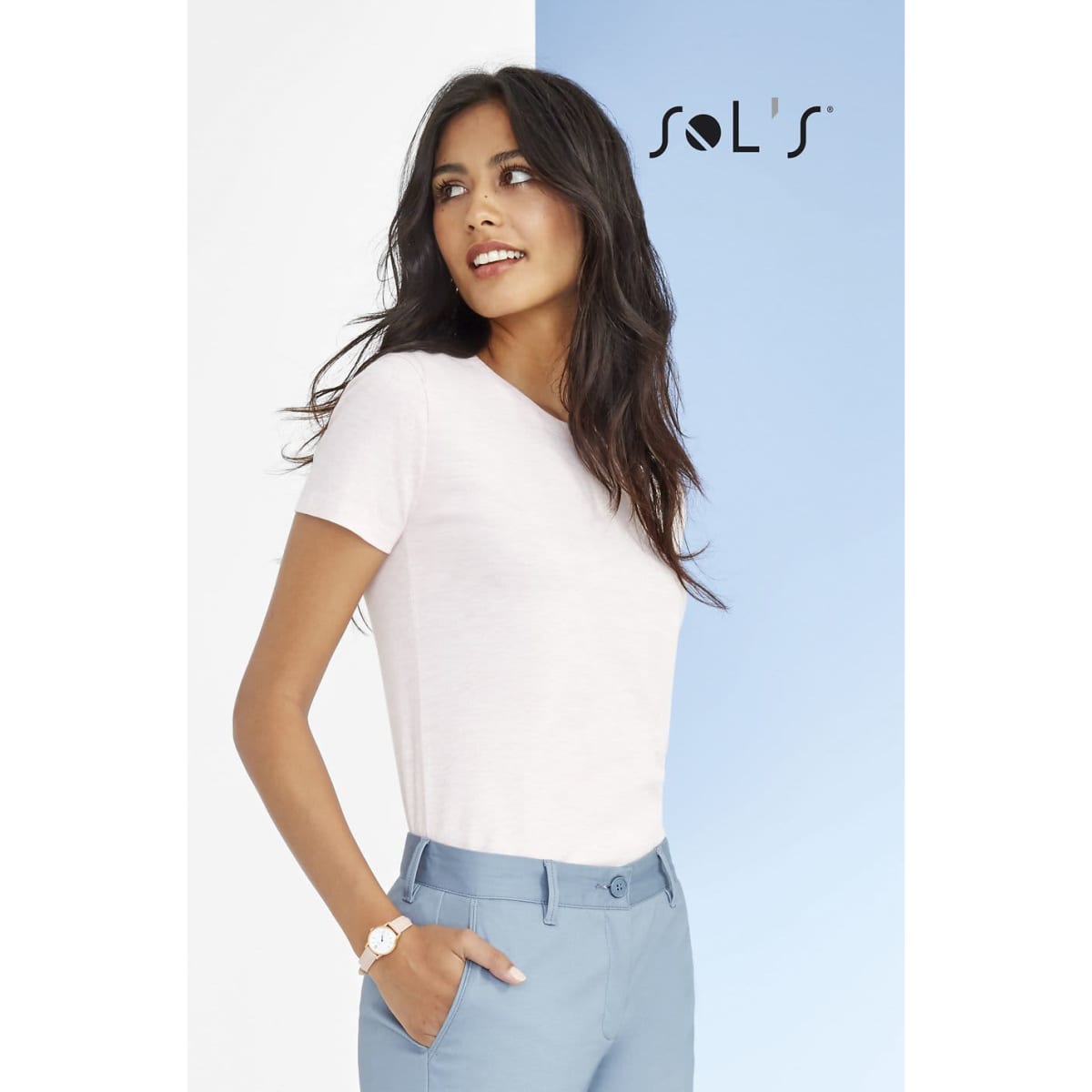 A model wearing light pink fitted t-shirt and light blue trousers, with a logo in the corner.